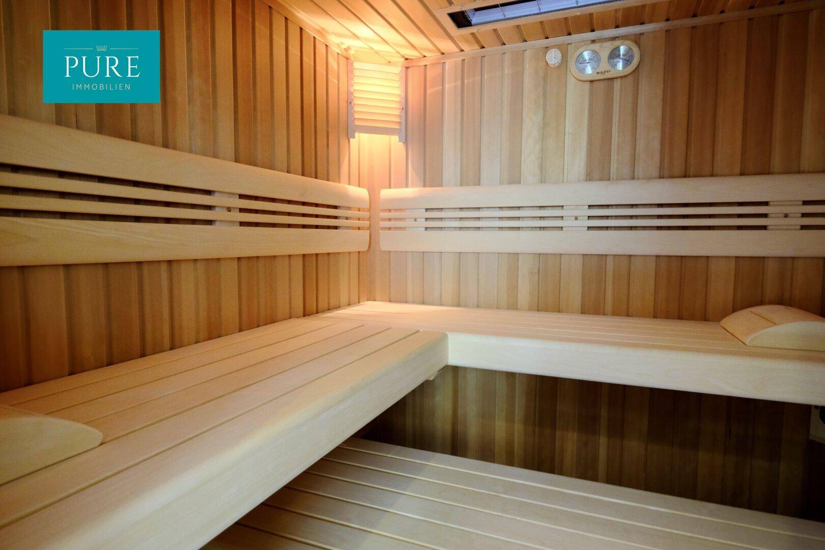 Innenansicht einer holzverkleideten Sauna mit mehreren Sitzebenen.