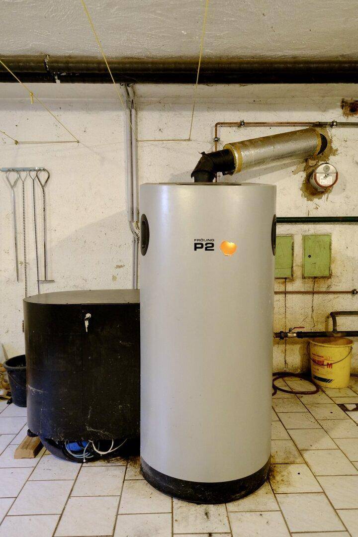 Heizungsraum im Keller mit modernem Pelletkessel und sichtbaren Installationen.