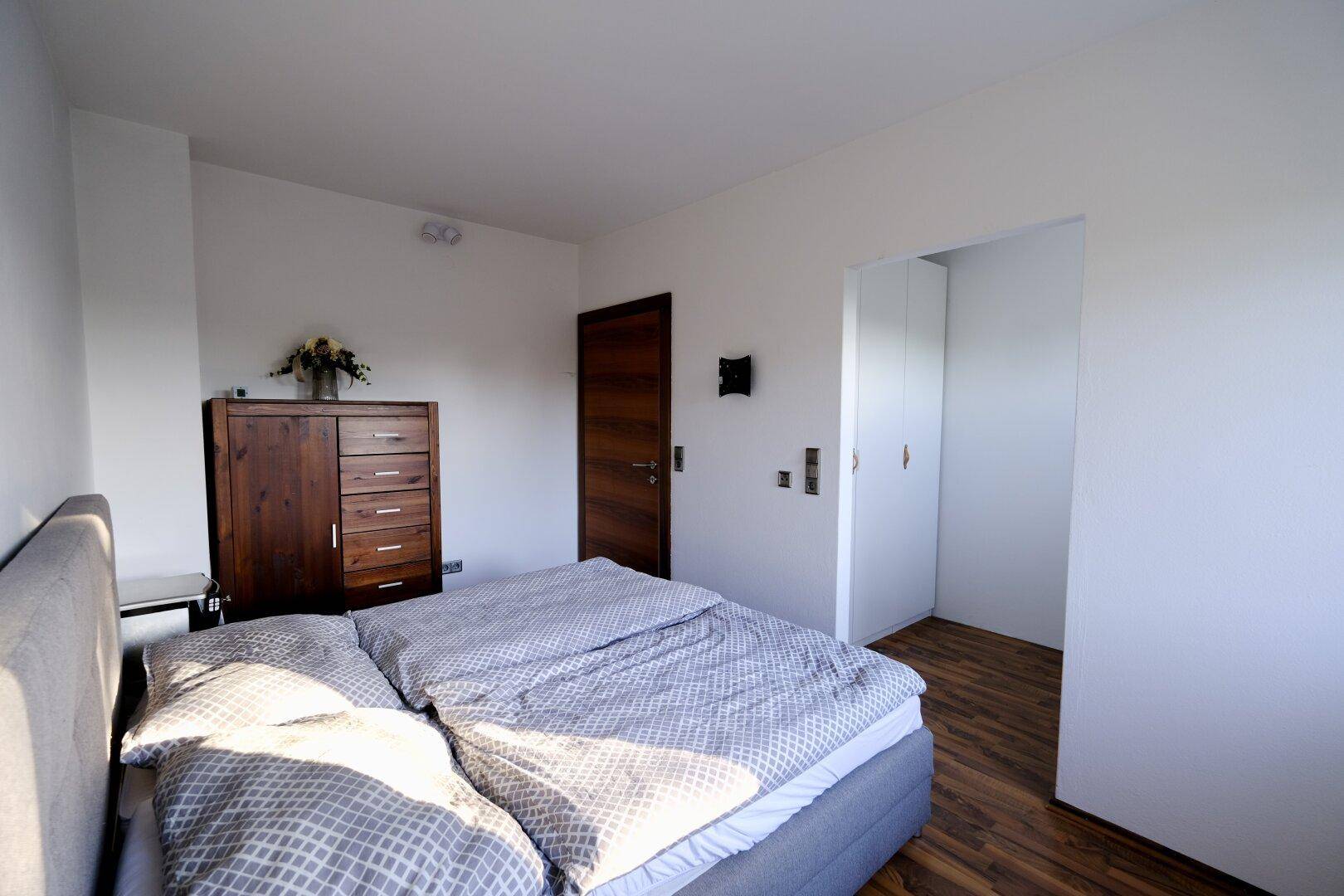 Geräumiges Schlafzimmer mit Doppelbett und Holzboden, bietet viel Platz und eine ruhige Atmosphäre.