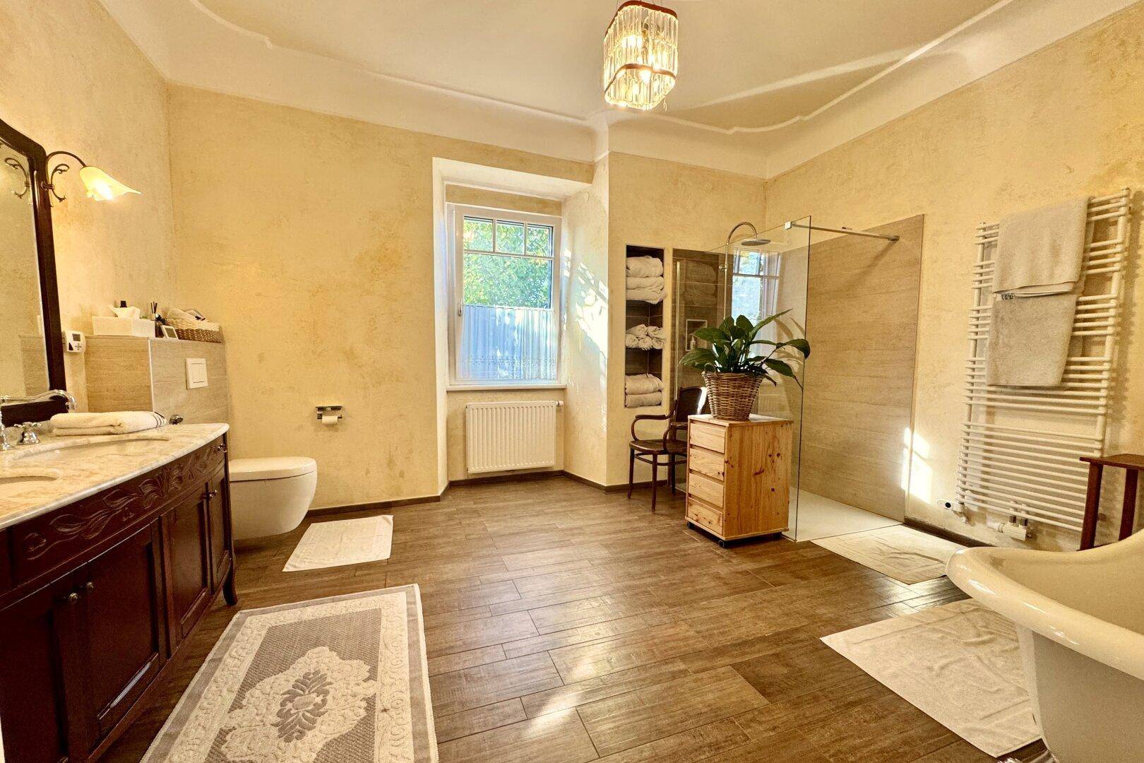 Großes Badezimmer mit freistehender Badewanne, begehbarer Dusche und Doppelwaschbecken.