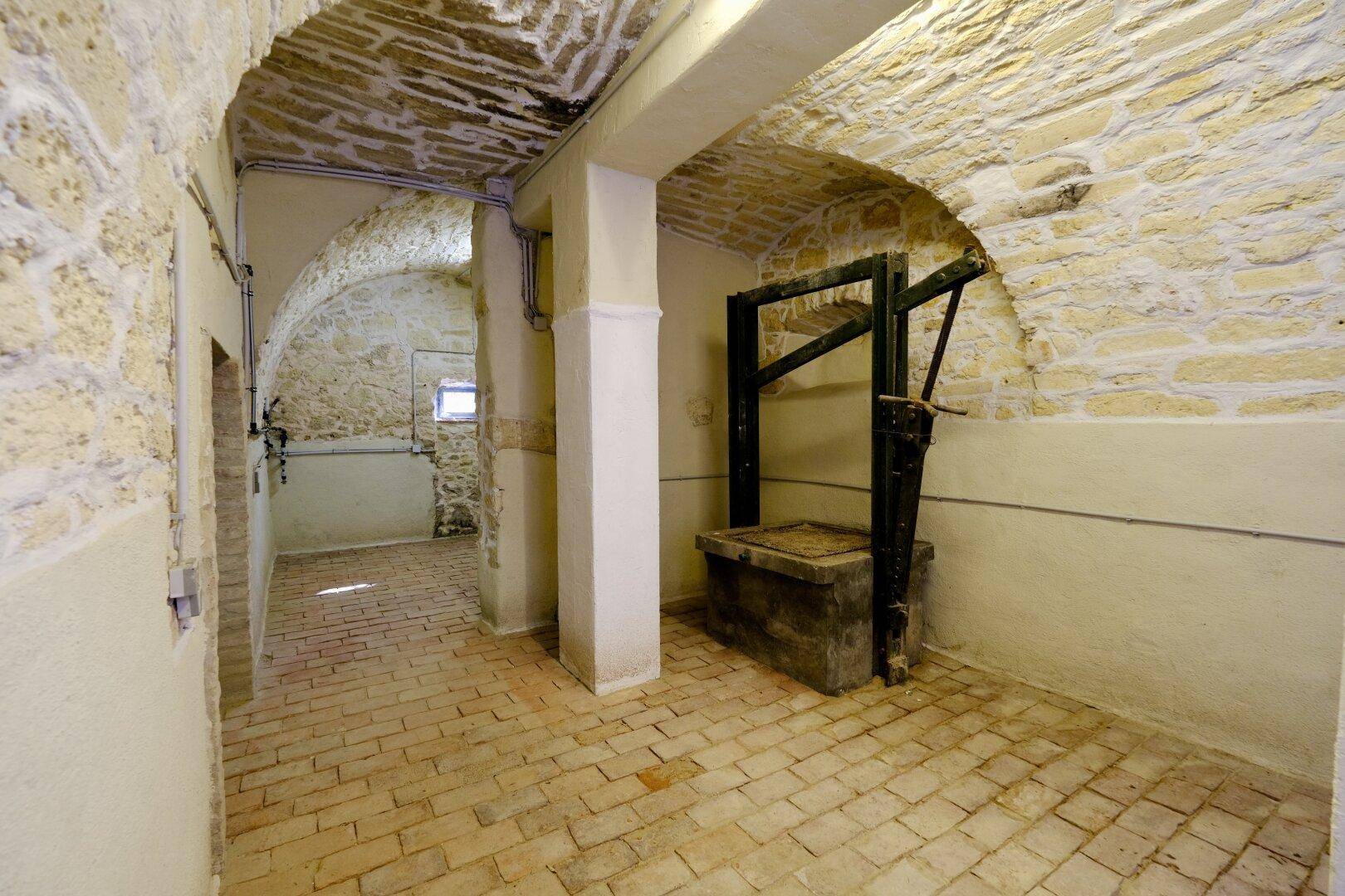 Historischer Kellerraum mit Gewölbedecken, Natursteinwänden und Ziegelboden.