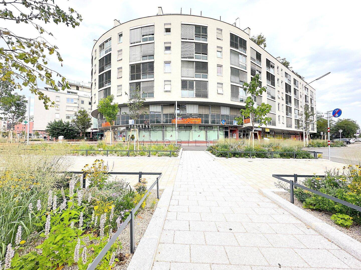 Panoramablick auf das moderne Gebäude mit seiner geschwungenen Architektur und der begrünten Umgebung.