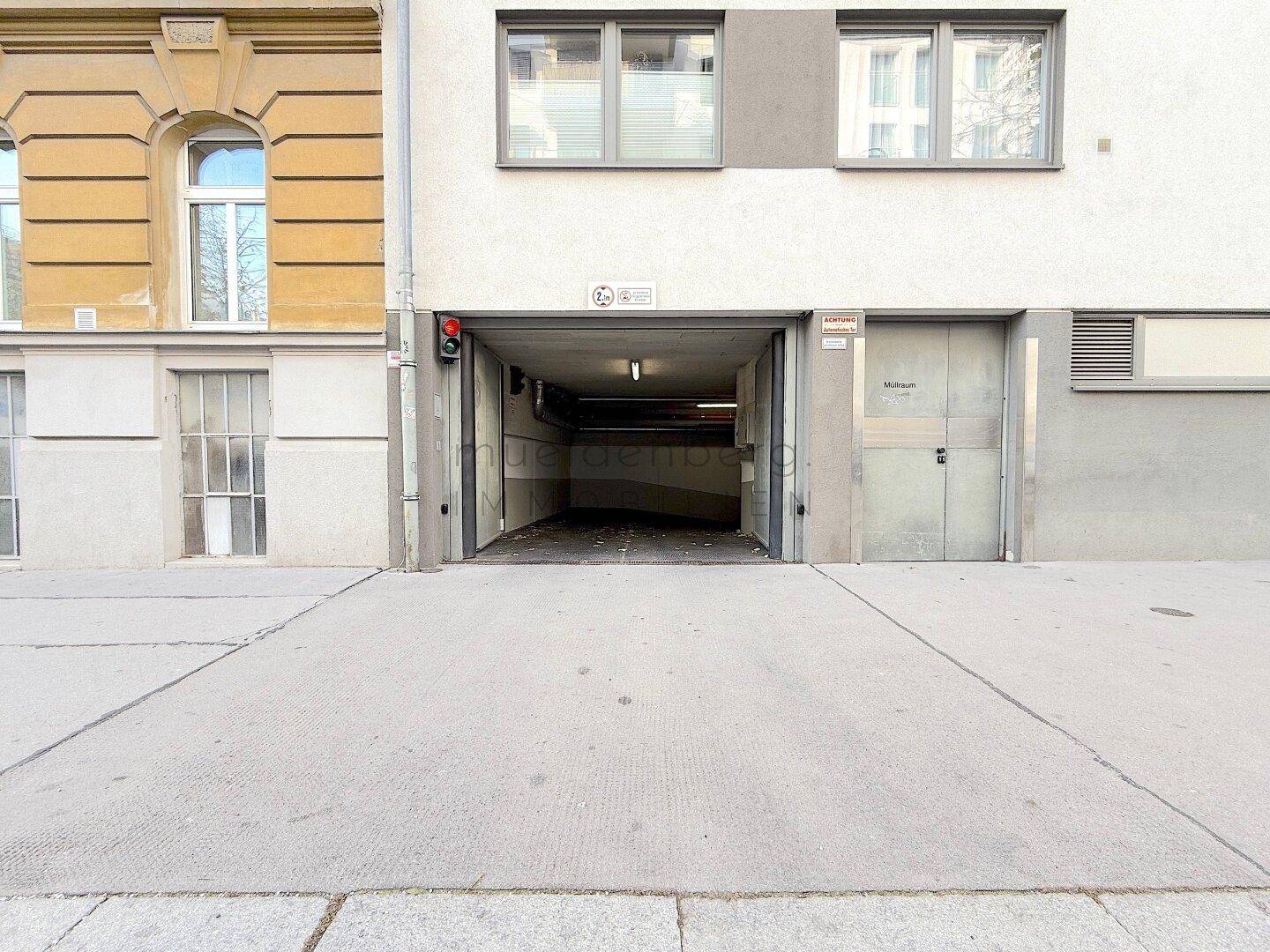 Einfahrt zur Tiefgarage mit Rampe und Ampelsystem.