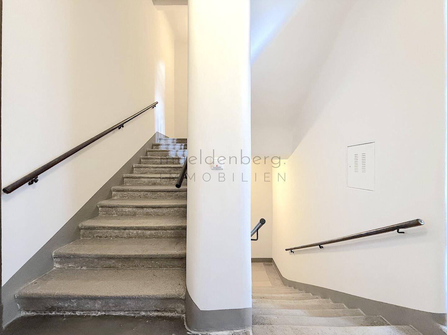 Schlichtes Treppenhaus mit Betonstufen und Handläufen, typisch für ein Mehrfamilienhaus.