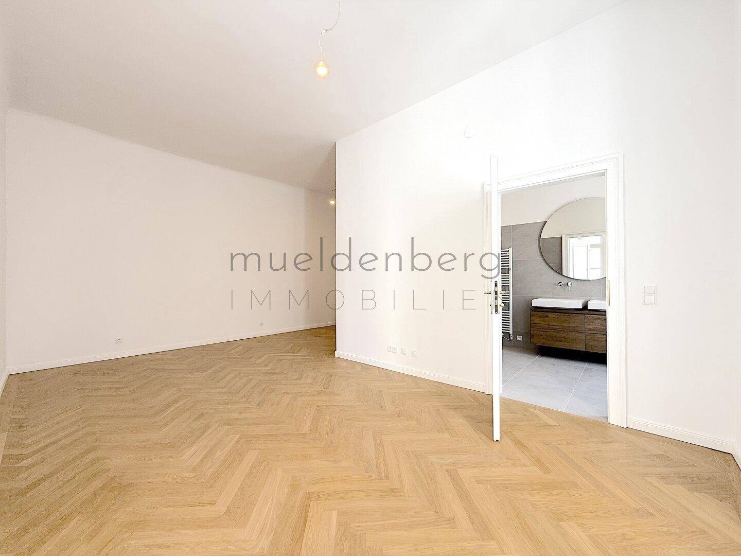 Modernes Badezimmer mit Doppelwaschbecken, beleuchtetem Spiegel und begehbarer Dusche.