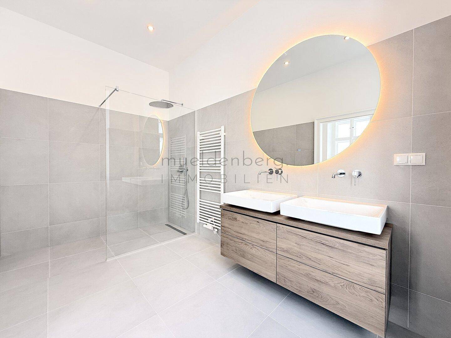 Elegantes Badezimmer mit Doppelwaschbecken, großem Spiegel und geräumiger begehbarer Dusche.