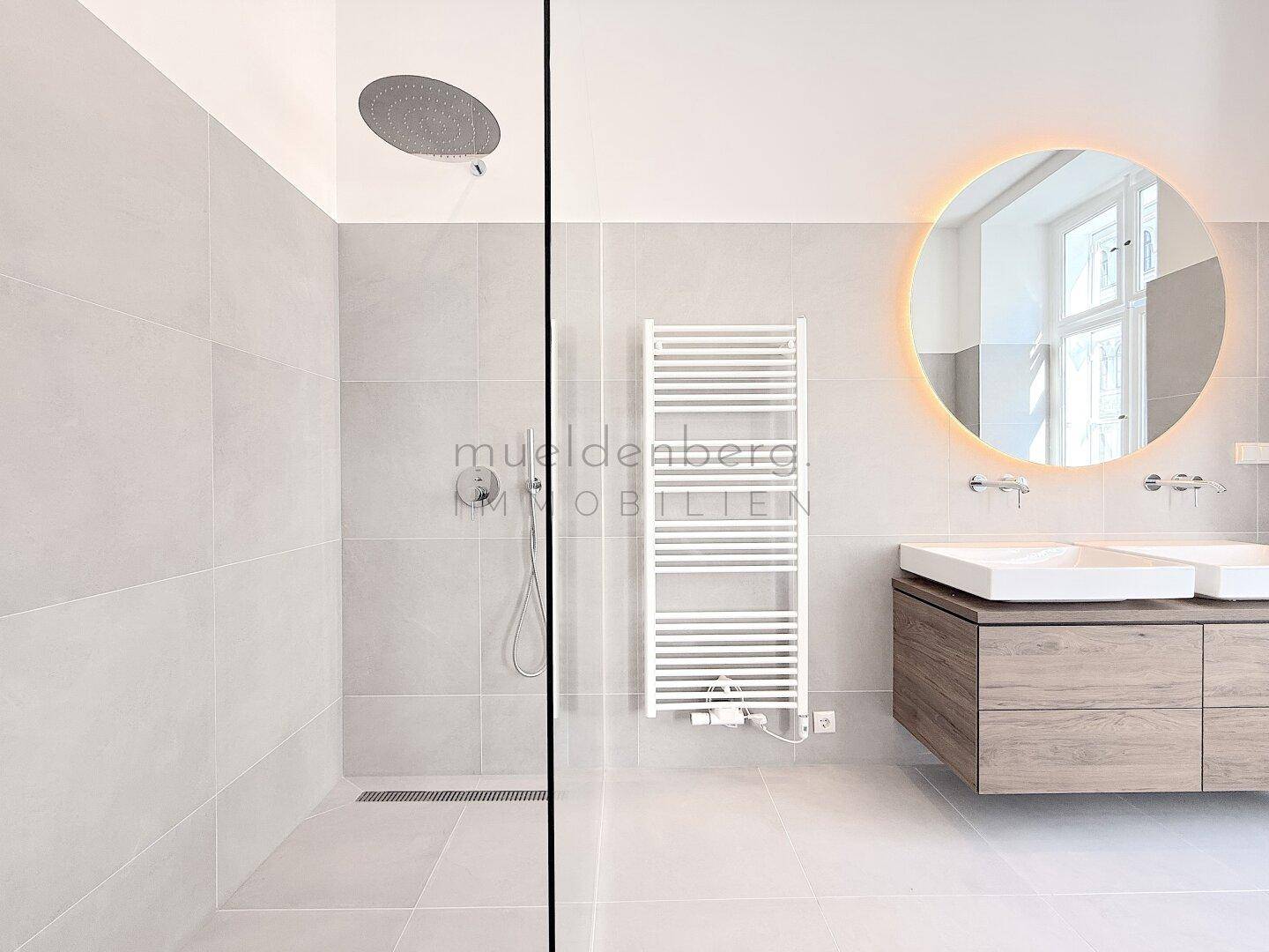 Detailansicht der modernen begehbaren Dusche mit Regendusche und beheiztem Handtuchhalter.