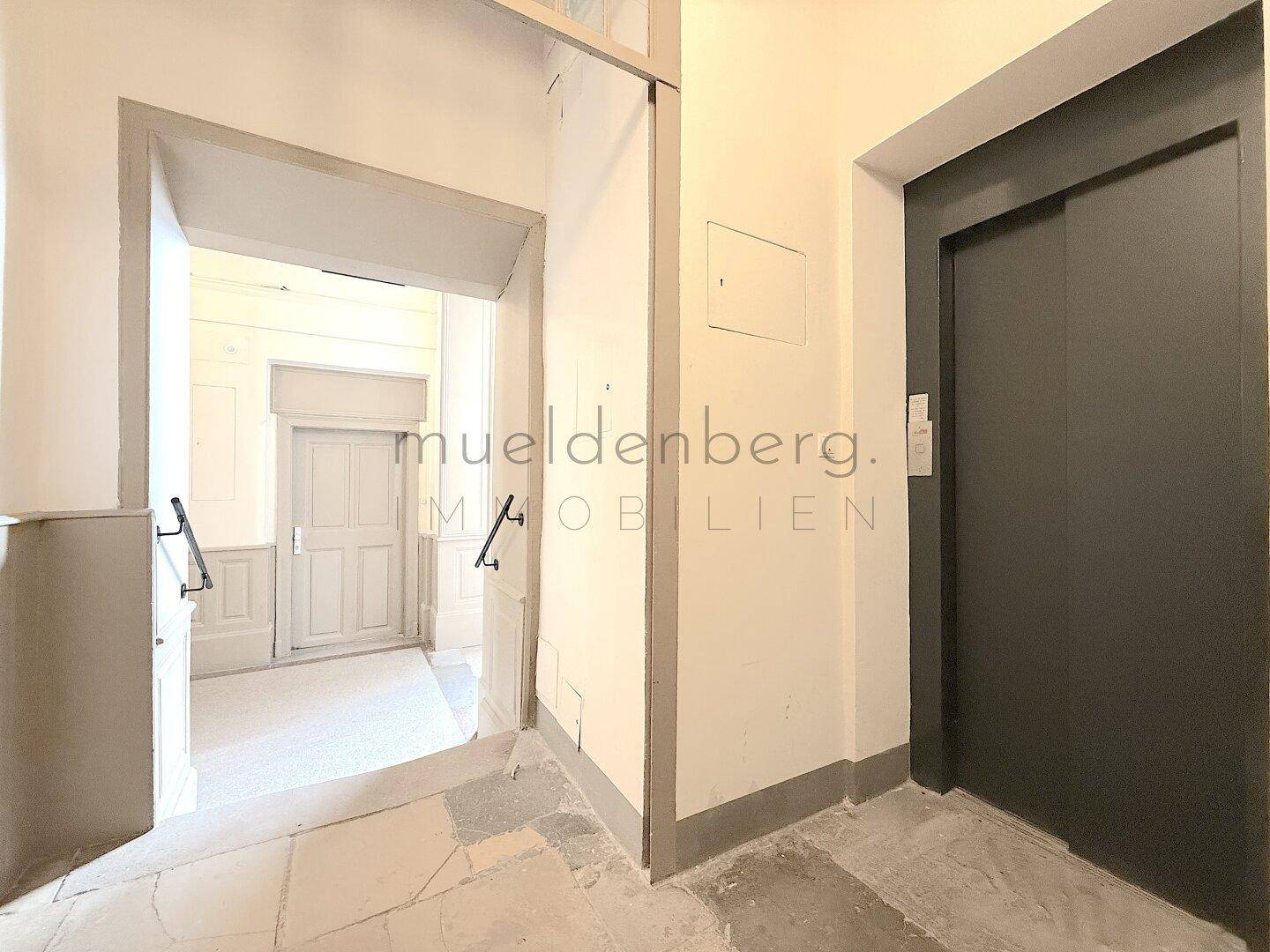 Beeindruckendes Treppenhaus mit geschwungenen Stufen und kunstvollen Deckenmalereien.