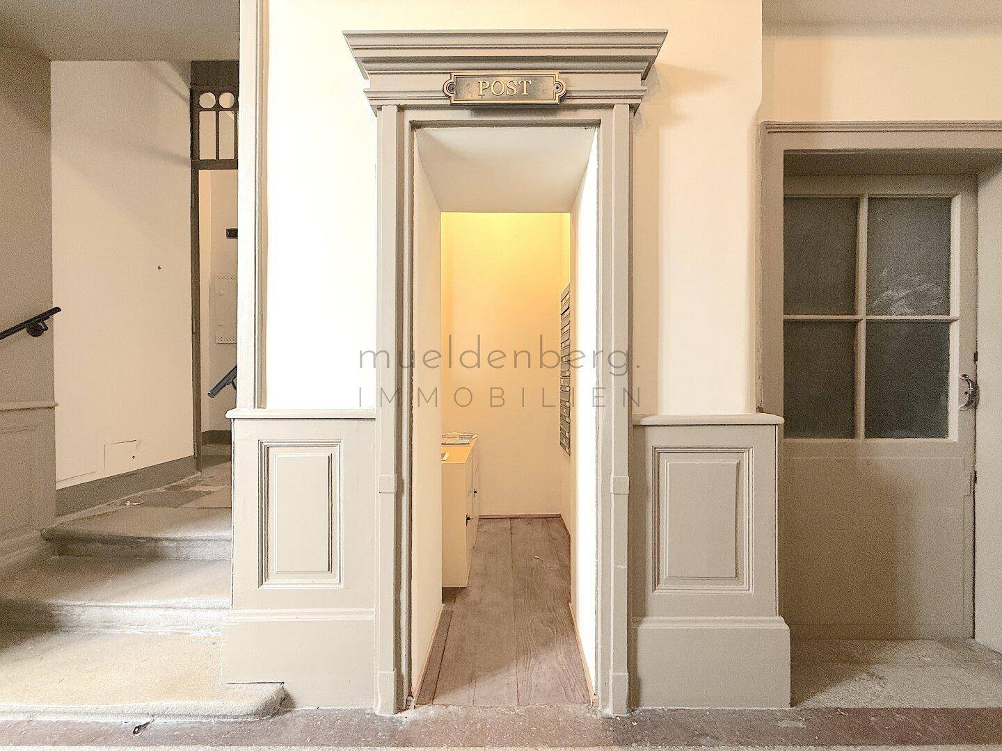Detailansicht des Eingangs zum Postbereich im historischen Flur, mit klassischer Architektur.