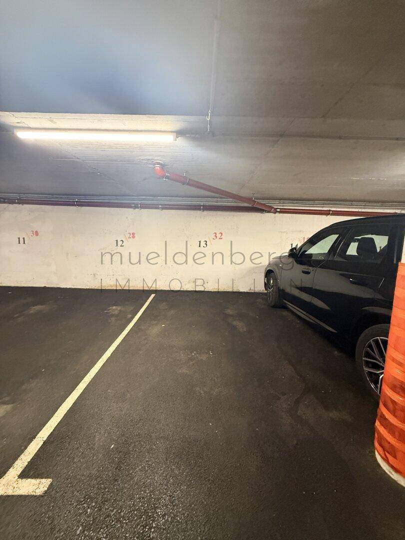 Tiefgaragenstellplatz mit Markierungen und geparktem Fahrzeug.