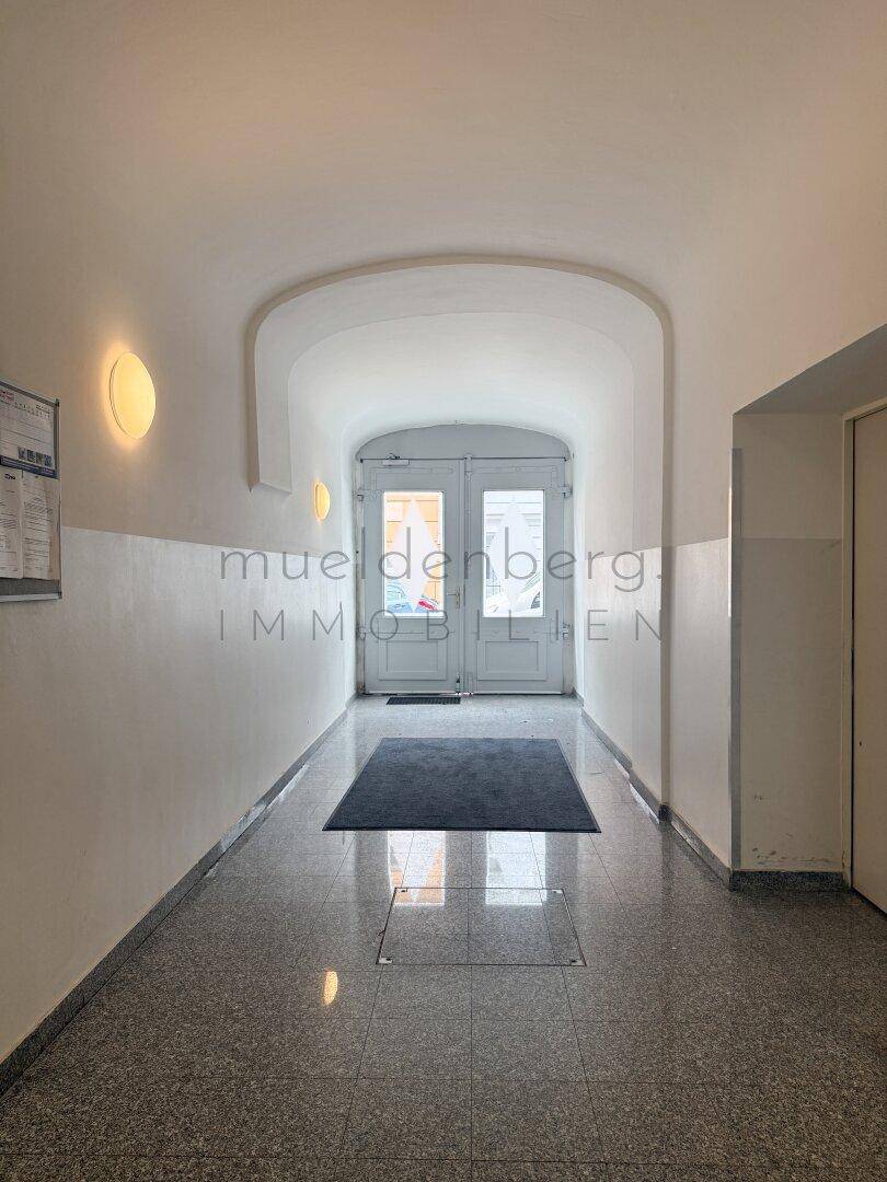 Heller Eingangsbereich mit Granitboden und gewölbter Decke in einem Altbau.