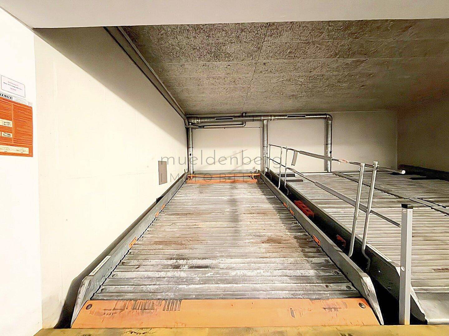 Leeres mechanisches Parksystem in einer Tiefgarage, bereit für ein Fahrzeug.