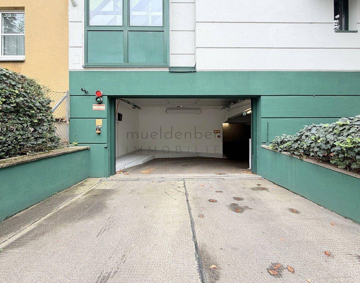 Eingang zur Tiefgarage mit grüner Fassadengestaltung und Zufahrtsbereich.