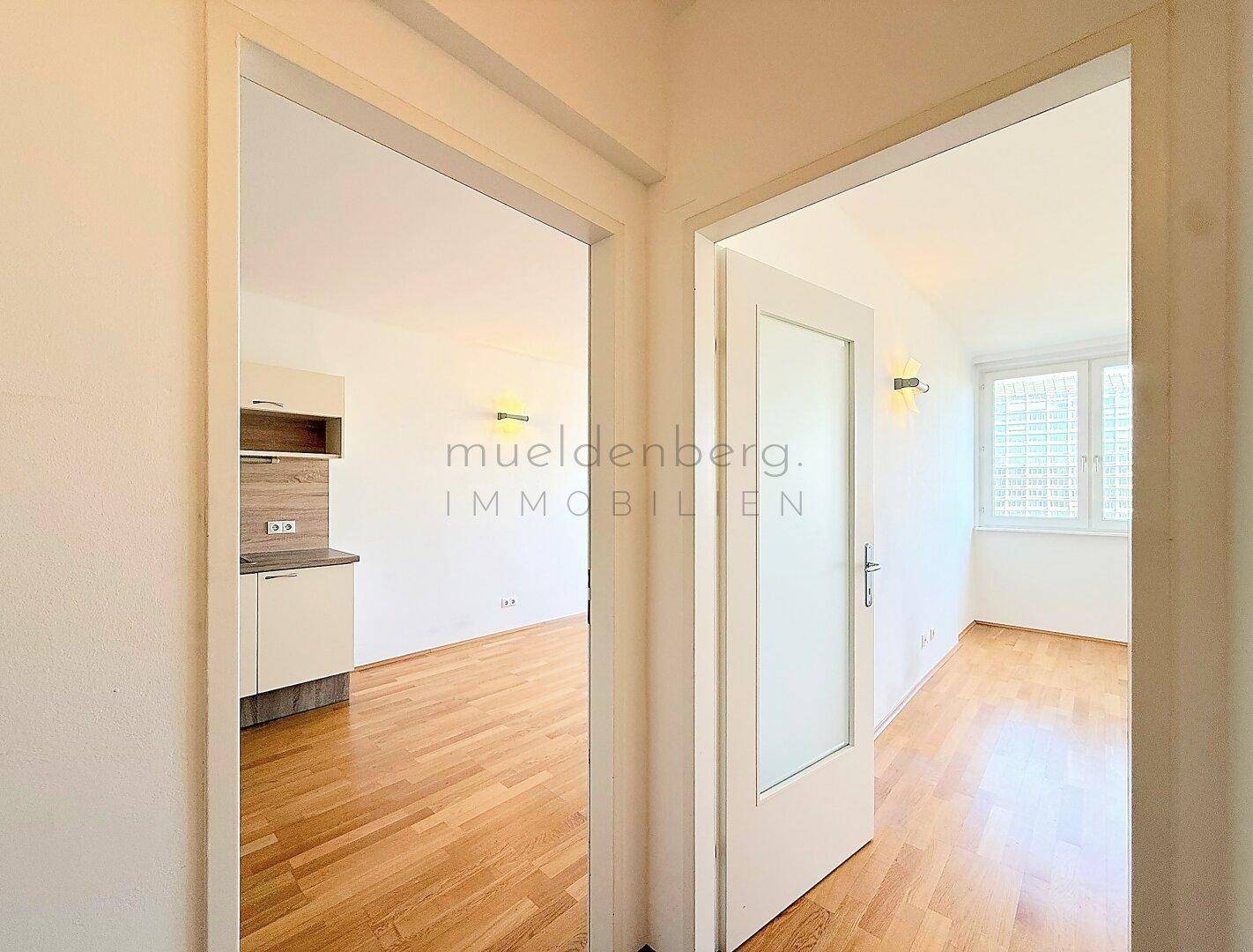 Blick aus dem Flur in die Küchenzeile und den angrenzenden Wohnbereich.