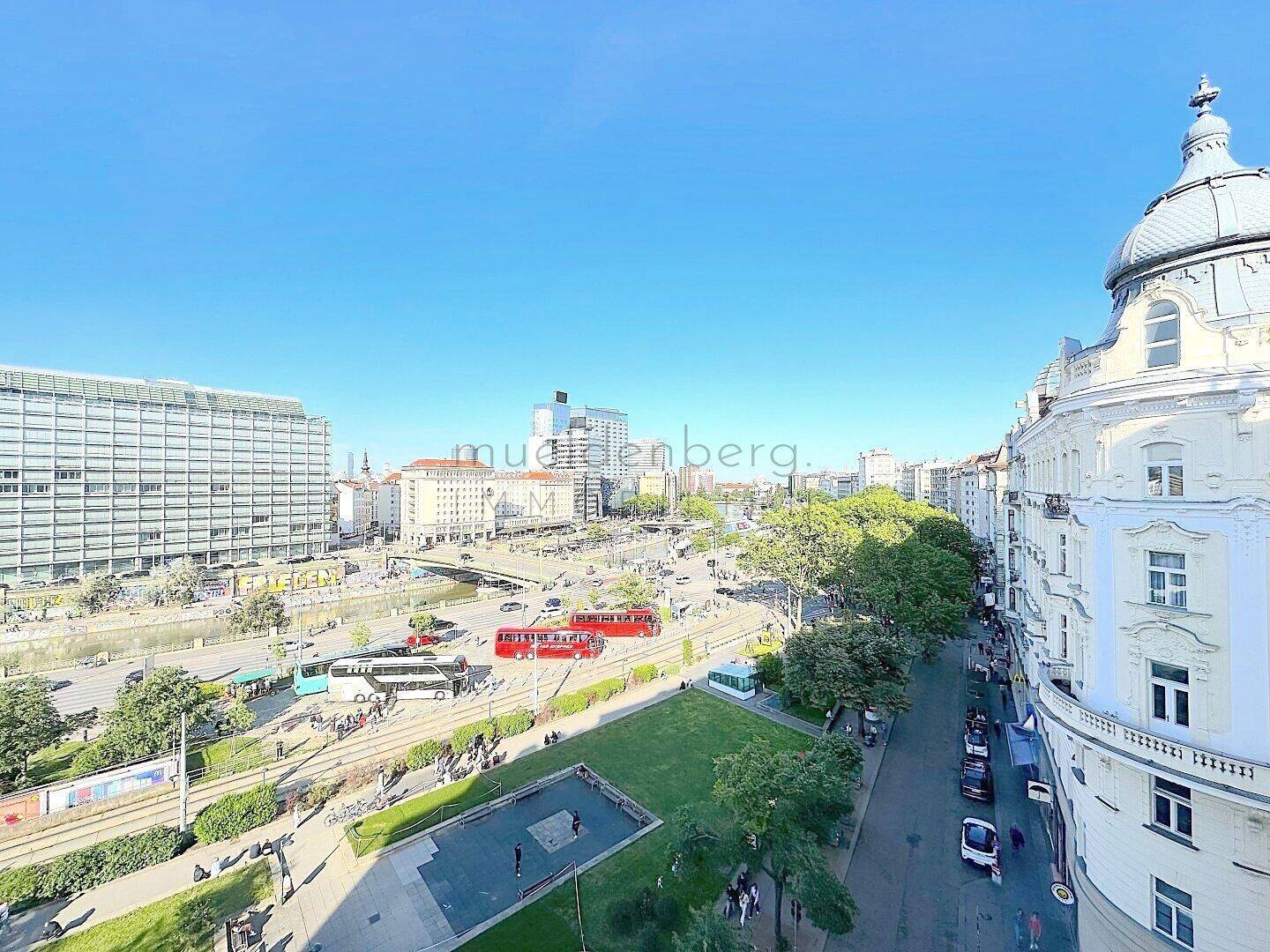 Städtisches Panorama mit historischen und modernen Gebäuden, Straßen und Grünflächen.