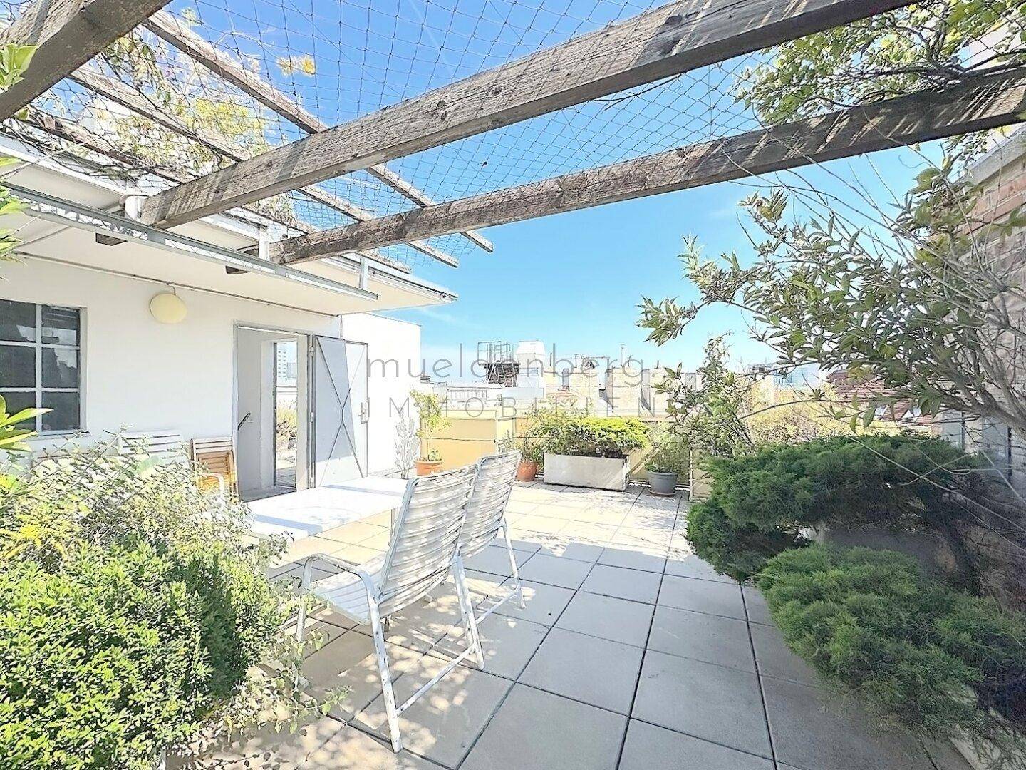 Geräumige Dachterrasse mit Pergola, Essbereich im Freien und üppiger Bepflanzung für entspannte Stunden.