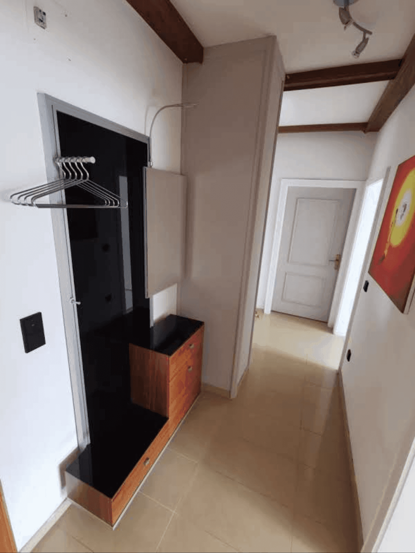 Moderner Eingangsbereich mit Garderobe, Holzschrank und sichtbaren Holzbalken an der Decke.