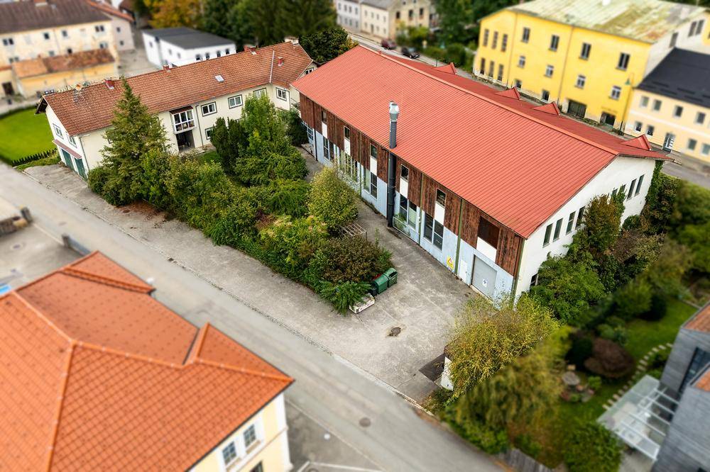 Luftaufnahme des Gebäudekomplexes mit großem Hofbereich und angrenzenden Grünflächen, eingebettet in die Umgebung.