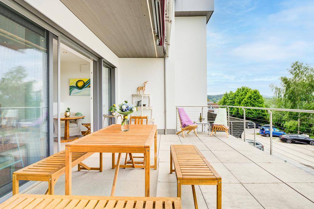 Weitläufige Terrasse mit Essbereich und Liegestühlen, die einen Panoramablick bietet.