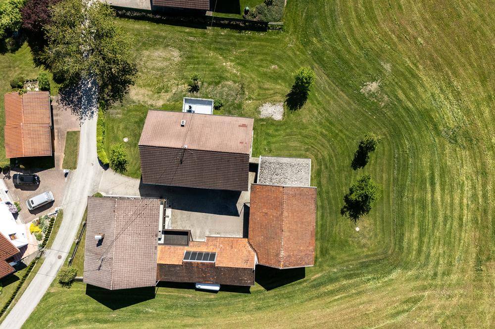 Senkrechte Luftaufnahme des Anwesens mit Gebäuden und umliegenden Grünflächen.
