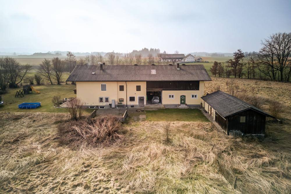 Vogelperspektive des Landguts mit Hauptgebäude, Nebengebäude und angrenzenden Feldern.