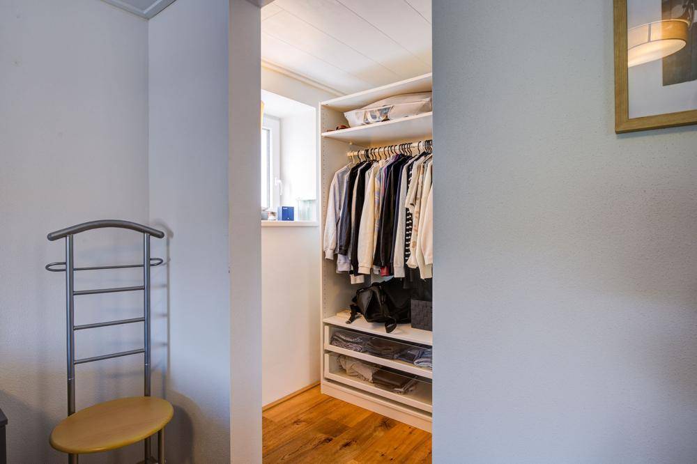 Praktischer begehbarer Kleiderschrank mit Regalen und Kleiderstangen für viel Stauraum.