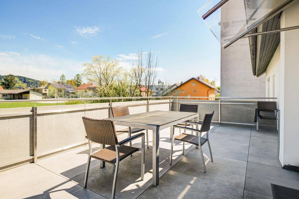 Geräumiger Balkon mit Sitzgelegenheiten und Blick auf die umliegende Wohngegend.