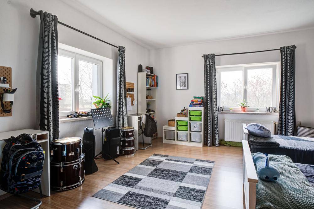 Geräumiges Kinderzimmer mit zwei Betten, Schreibtisch und Spielzeug, hell und freundlich.