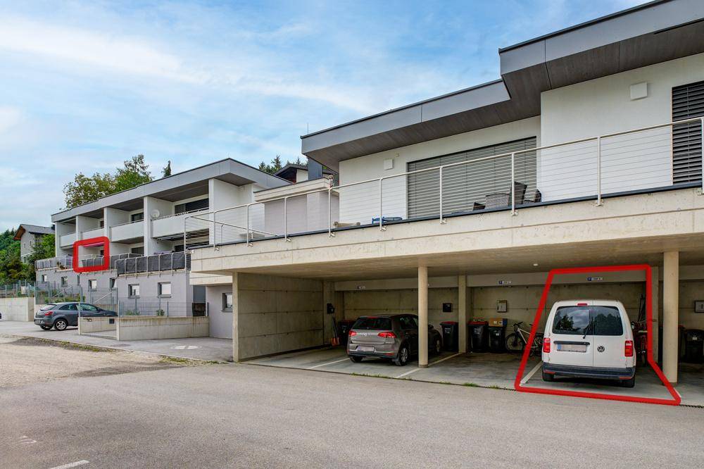 Moderne Wohnanlage mit Tiefgaragenstellplätzen und Balkonen, eingebettet in eine grüne Umgebung.