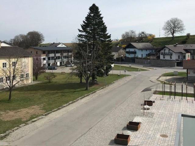 Weitläufige Außenansicht mit Straße, Gebäuden und viel Grün in der Umgebung.