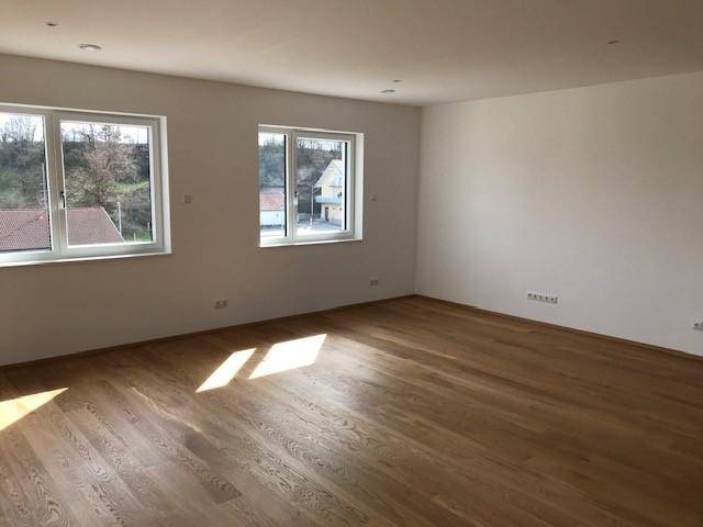 Heller Wohnraum mit Holzboden und weitem Blick durch die Fenster auf die Landschaft.