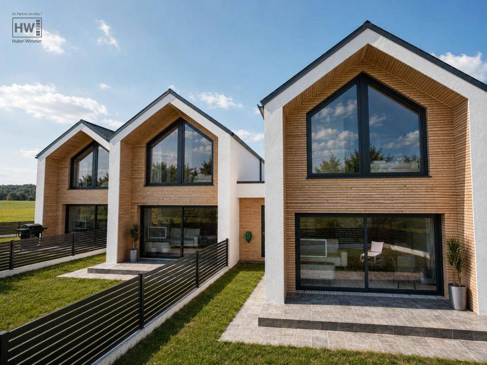 Zeitgenössische Häuser mit markanter Holzverkleidung und großen Glasfronten, umgeben von Grünflächen.
