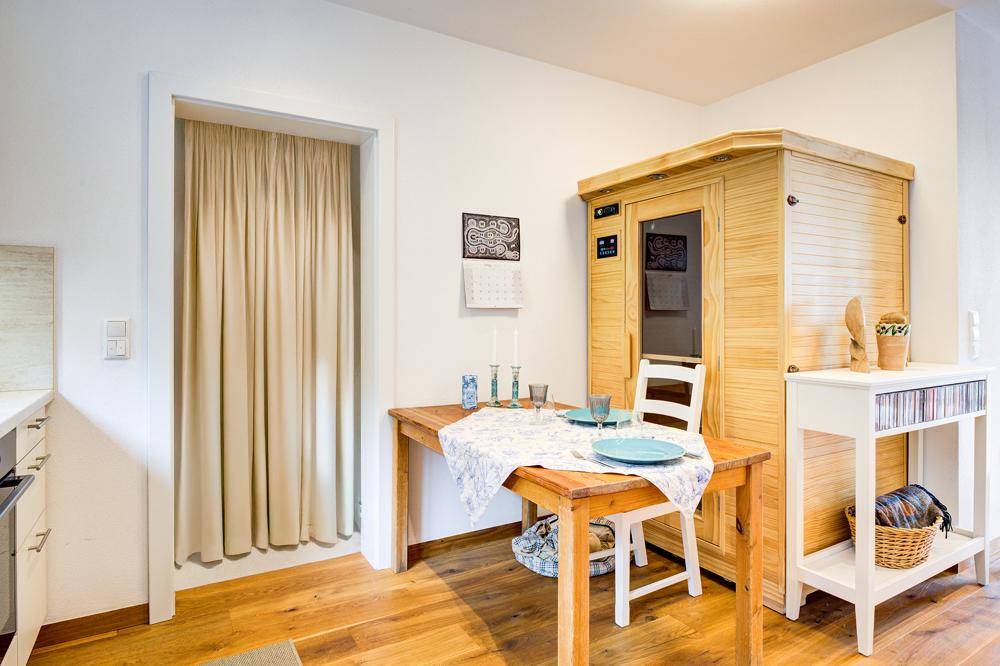 Essbereich mit Holztisch und integrierter Sauna, die zum Entspannen einlädt.