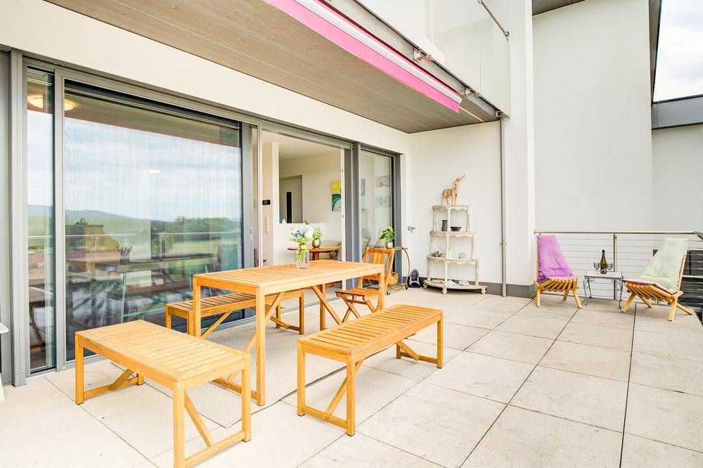 Geräumige Terrasse mit verschiedenen Sitzbereichen und weitem Blick auf die umliegende Natur.