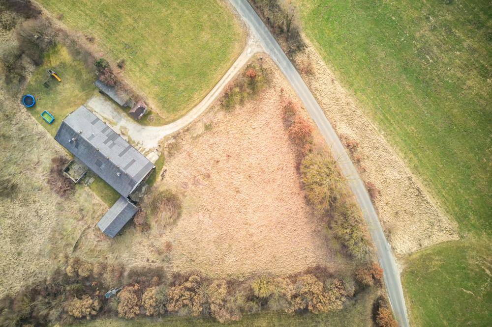 Luftaufnahme des Grundstücks mit angrenzender Straße und weiten Feldern in ländlicher Umgebung.