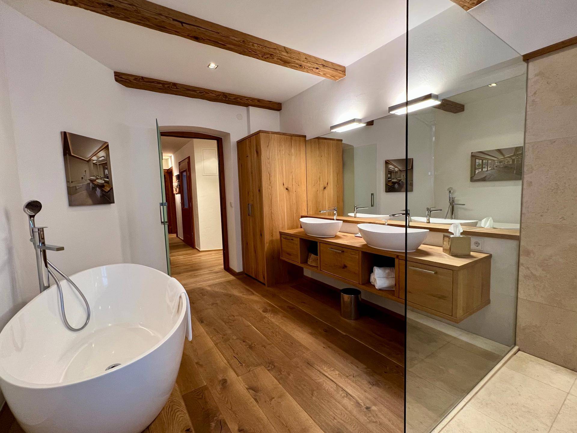 Geräumiges Badezimmer mit freistehender Badewanne, Doppelwaschbecken und begehbarer Dusche.