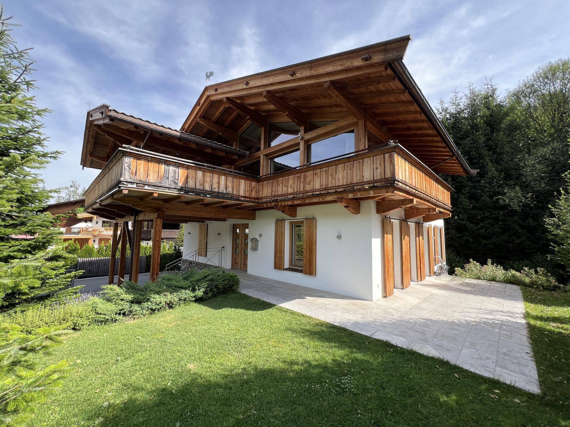 Charmantes Chalet mit traditioneller Holzarchitektur, großem Garten und gepflegter Grünfläche.