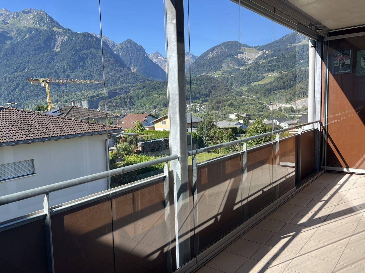 Verglaste Loggia mit Fliesenboden bietet einen weiten Blick auf die umliegende Berglandschaft.