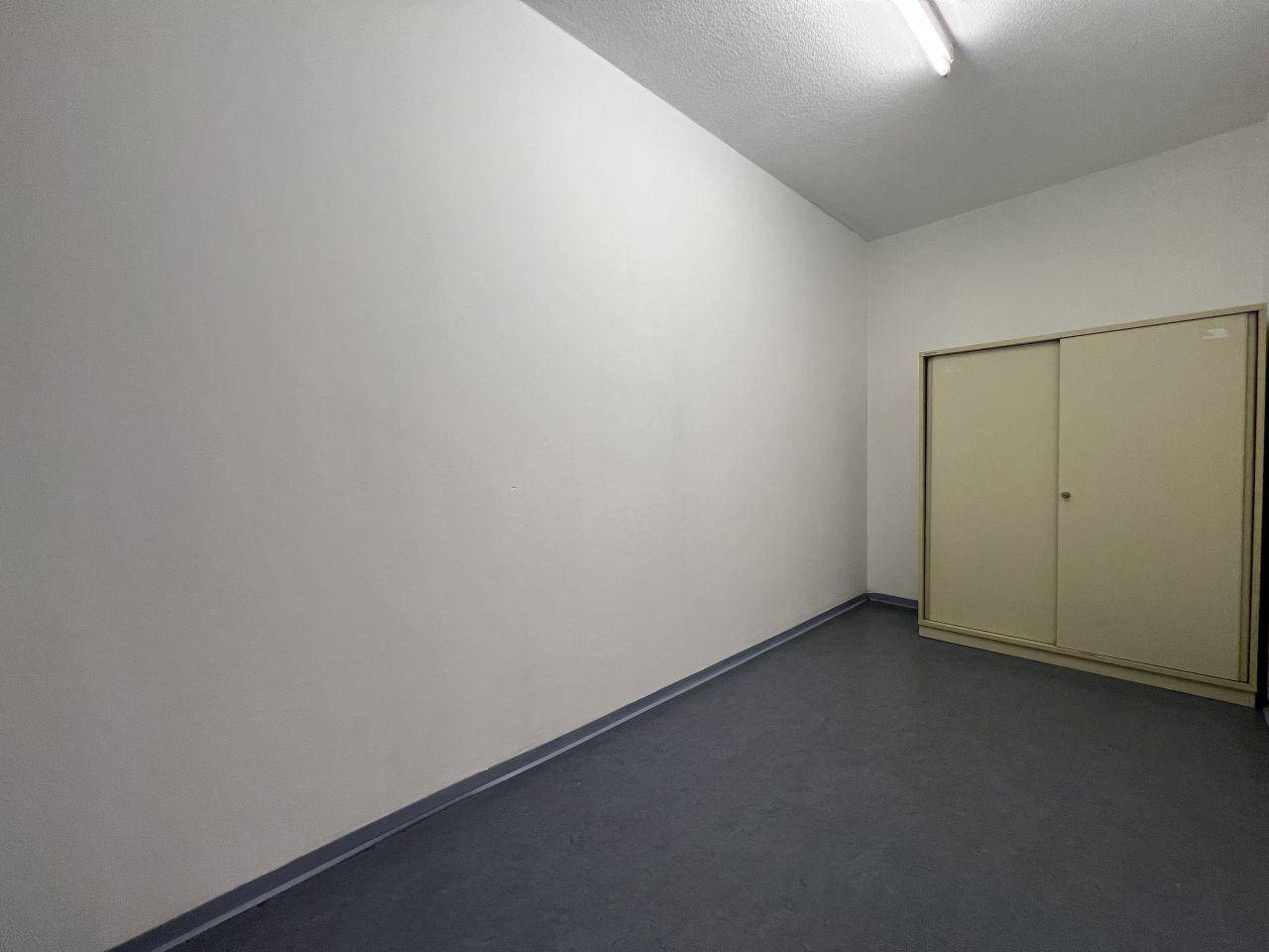Praktischer Abstellraum mit grauem Boden und einem großen Schrank mit Schiebetüren.