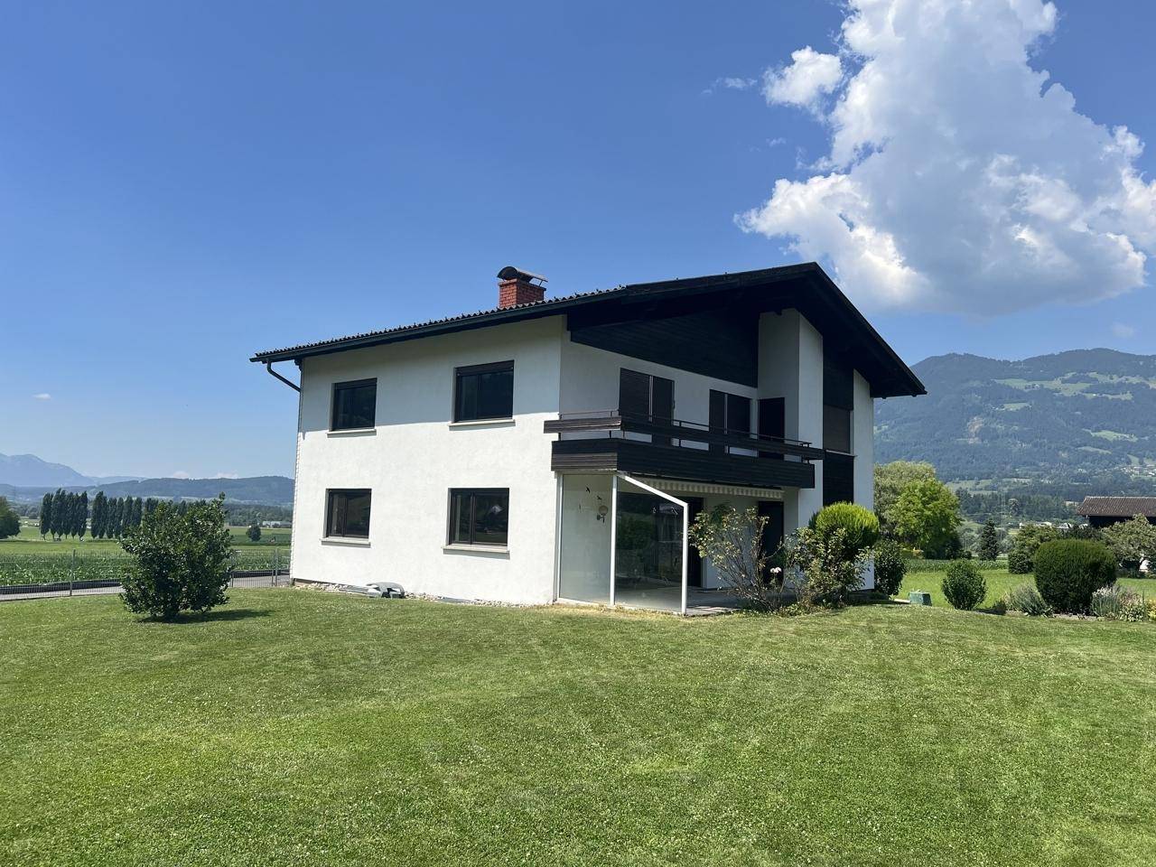 Freistehendes Einfamilienhaus mit gepflegtem Rasen und weitem Blick auf die umliegende Natur.