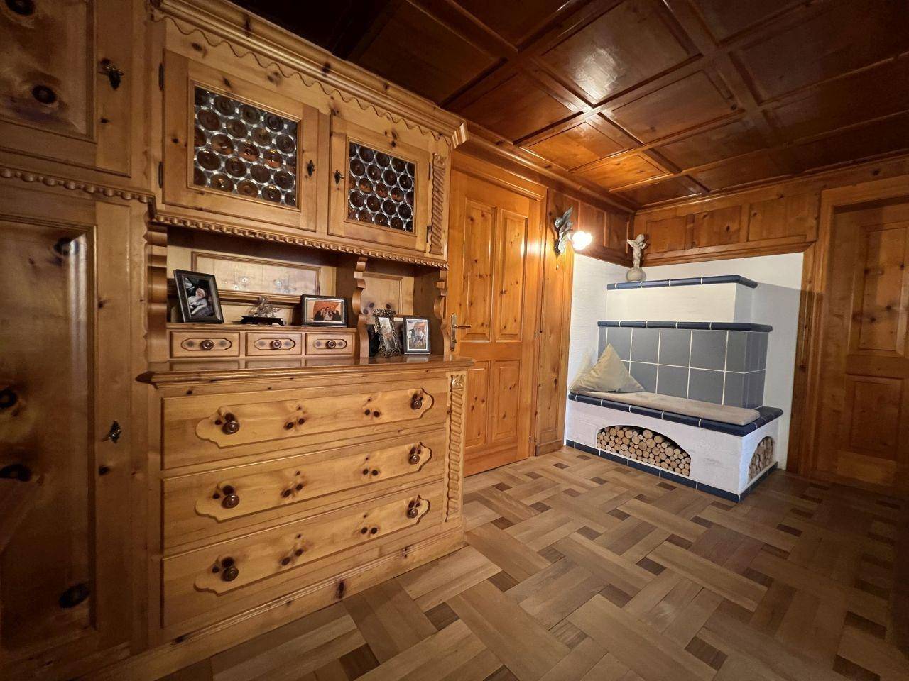 Traditioneller Eingangsbereich mit Holztäfelung, Kachelofen und rustikalen Möbeln.