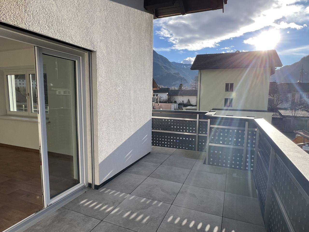 Geräumiger Balkon mit Fliesenboden und viel Sonnenlicht, bietet einen weiten Bergblick.