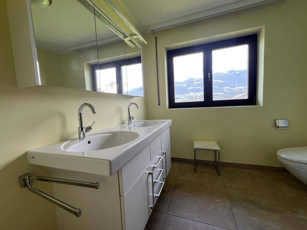 Helles Badezimmer mit Doppelwaschbecken, großem Fenster und Bergblick.