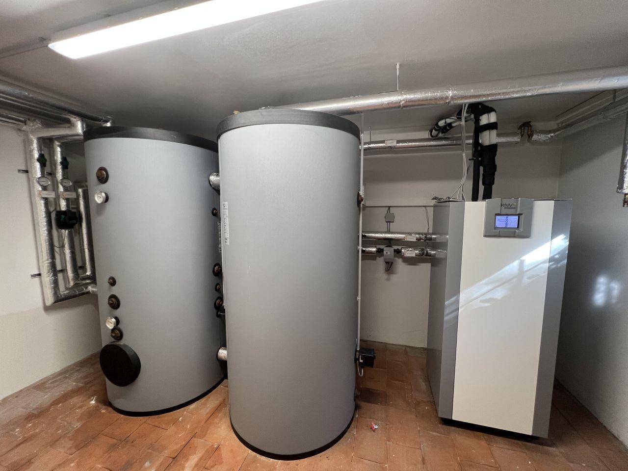 Heizungsraum mit zwei großen Warmwasserspeichern und einer modernen Heizungsanlage.