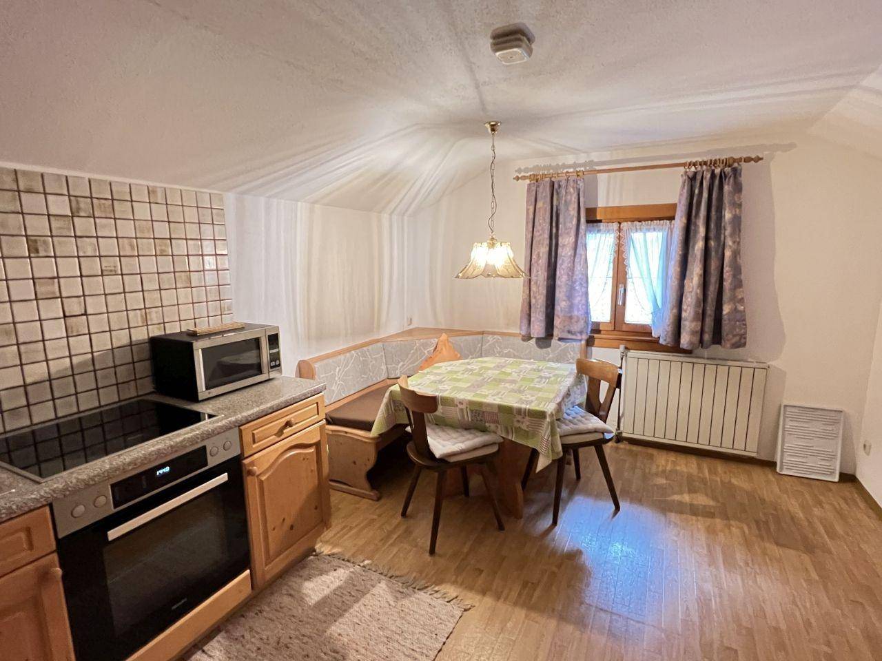 Traditionelle Küche mit Essbereich, Holzschränken und gefliestem Spritzschutz.