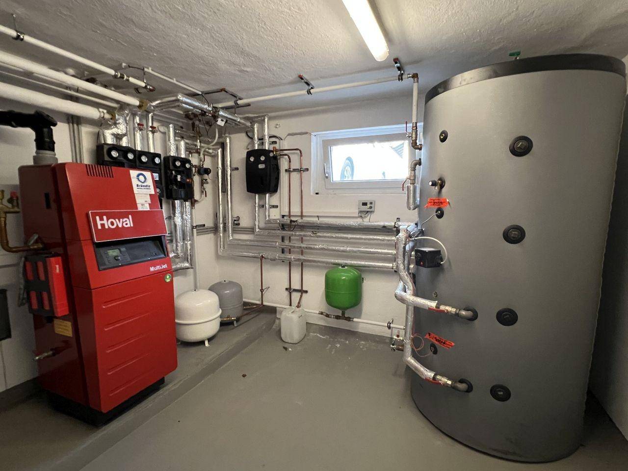 Technikraum mit moderner Heizungsanlage und Warmwasserspeicher, gut organisiert und funktional.