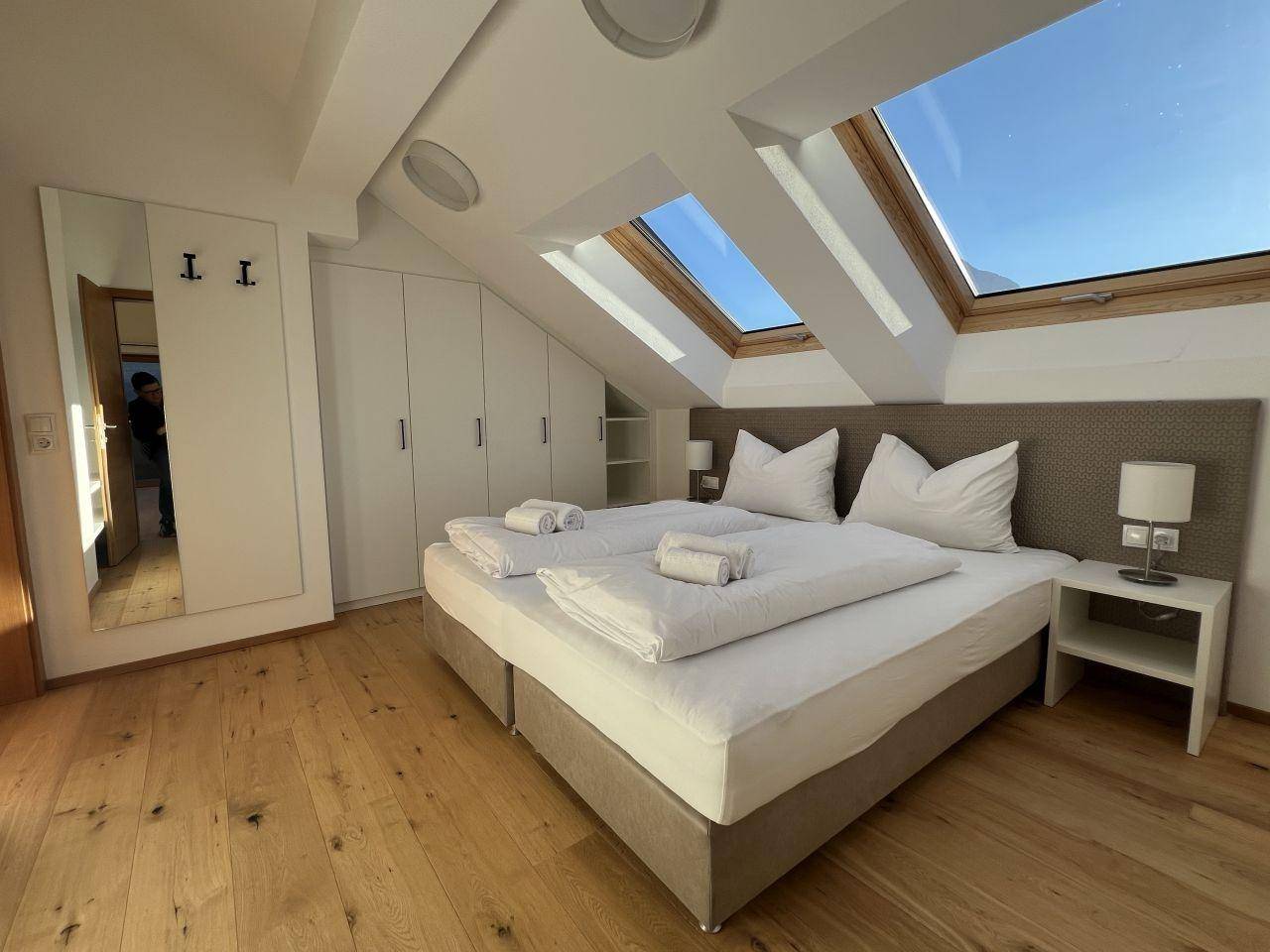 Gemütliches Schlafzimmer mit Doppelbett, Einbauschränken und mehreren Dachfenstern für viel Licht.
