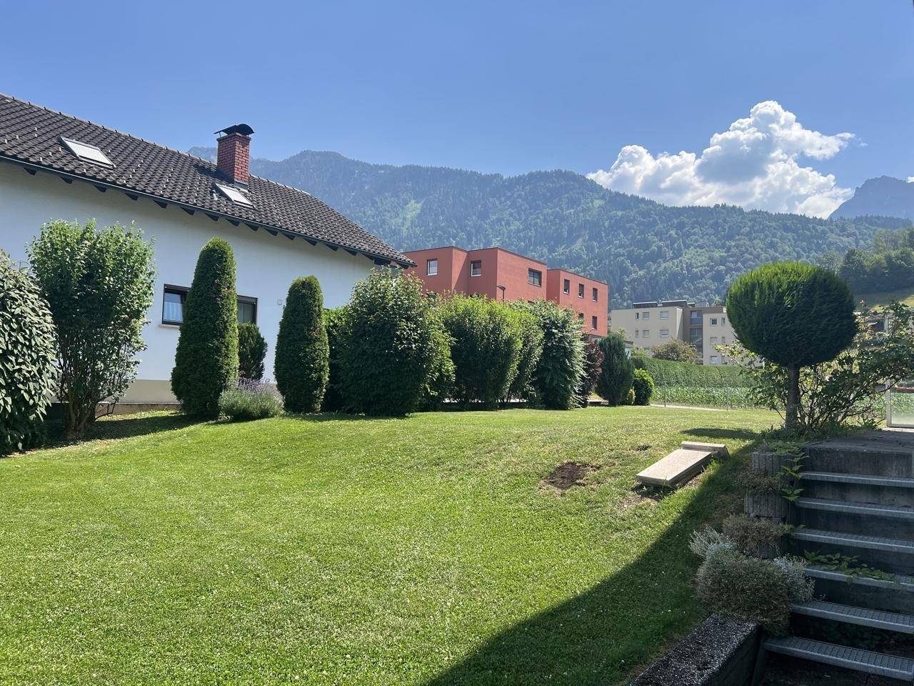 Gepflegter Gartenbereich mit Stufen und Blick auf die umliegende Berglandschaft.