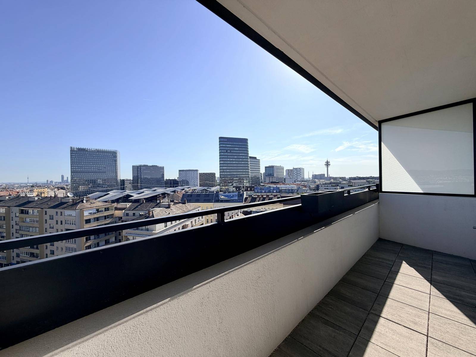 Geräumiger Balkon mit Fliesenboden und weitem Blick über die Stadt.