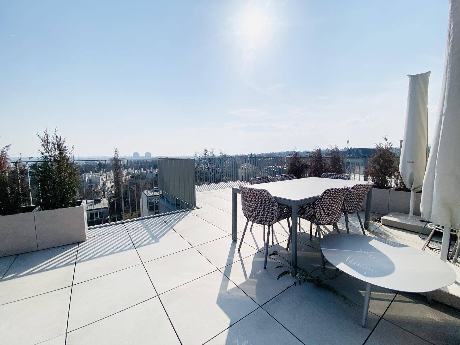 Möblierte Dachterrasse mit Esstisch und Stühlen, ideal für Mahlzeiten im Freien.